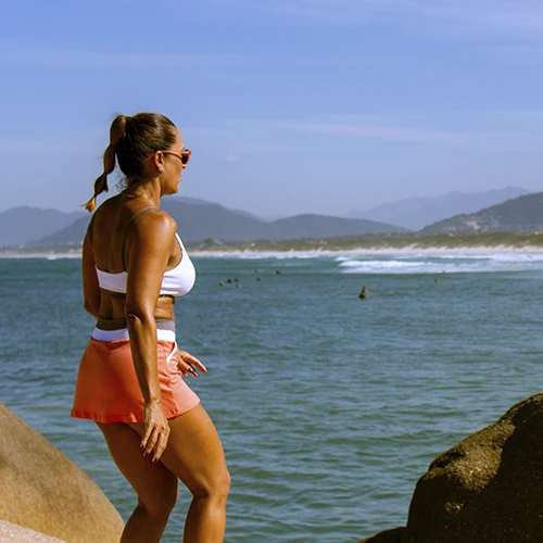 mulher na praia com roupa elegante